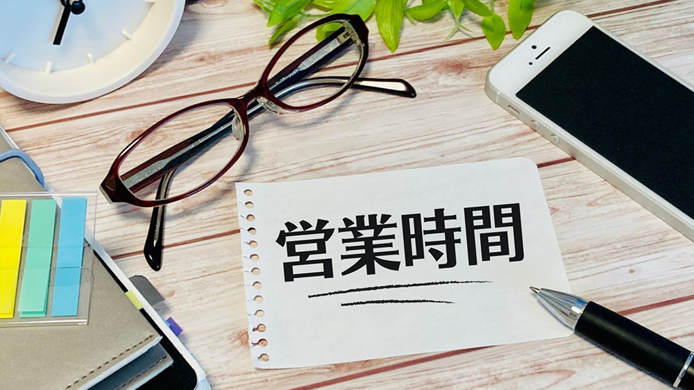 営業時間と書かれた紙が机に置いてある写真